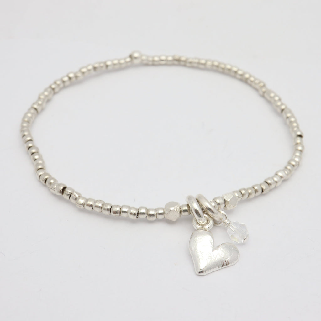 Silver heart pendant on fine silver beaded bracelet, featuring a clear Austrian crystal.
