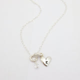 Silver initial-stamped heart necklace featuring a clear Austrian crystal