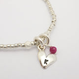 Silver heart beaded bracelet featuring a genuine ruby stone