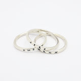 Three silver rings with engraved text on a white background