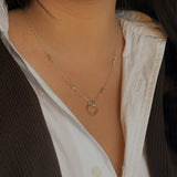Necklace with a circular pendant worn by a person
